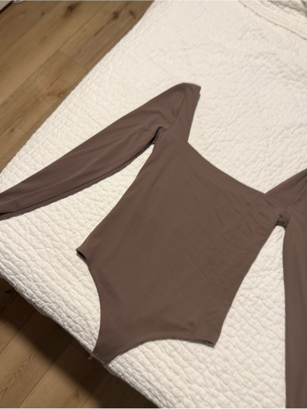 Nuuds long sleeve bodysuit in a neutral brown/taupe shade.
